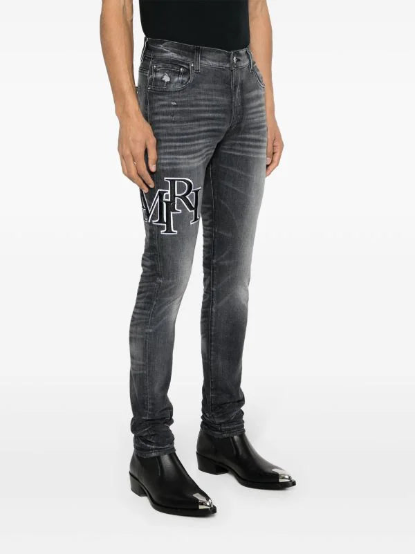 Amiri Men's Faded Skinny Jeans with Staggered Logo